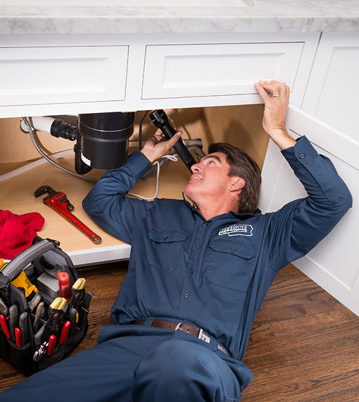 Plumber working under sink